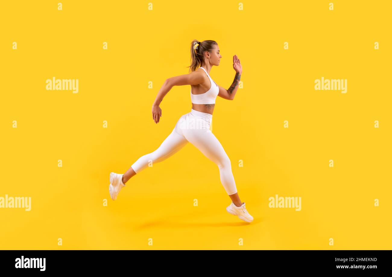 sport ragazza runner correre su sfondo giallo Foto Stock