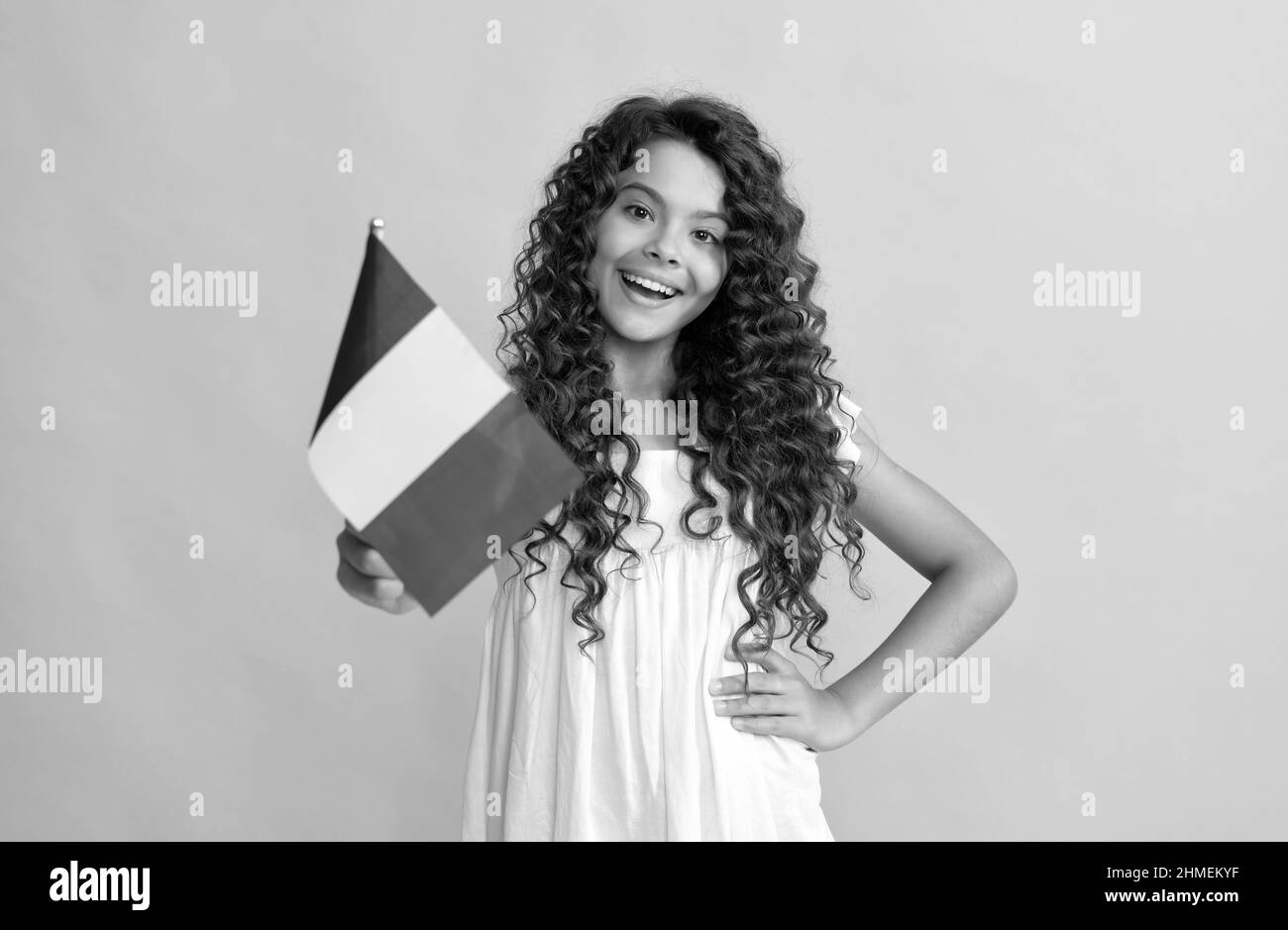 happy bambino lungo capelli ricci tenere bandiera francese, francia Foto Stock
