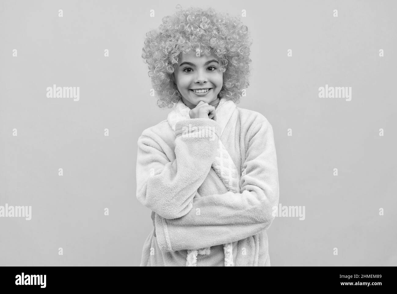 bambino allegro in fantasia parrucca arancione capelli indossare accappatoio casa, mattina Foto Stock