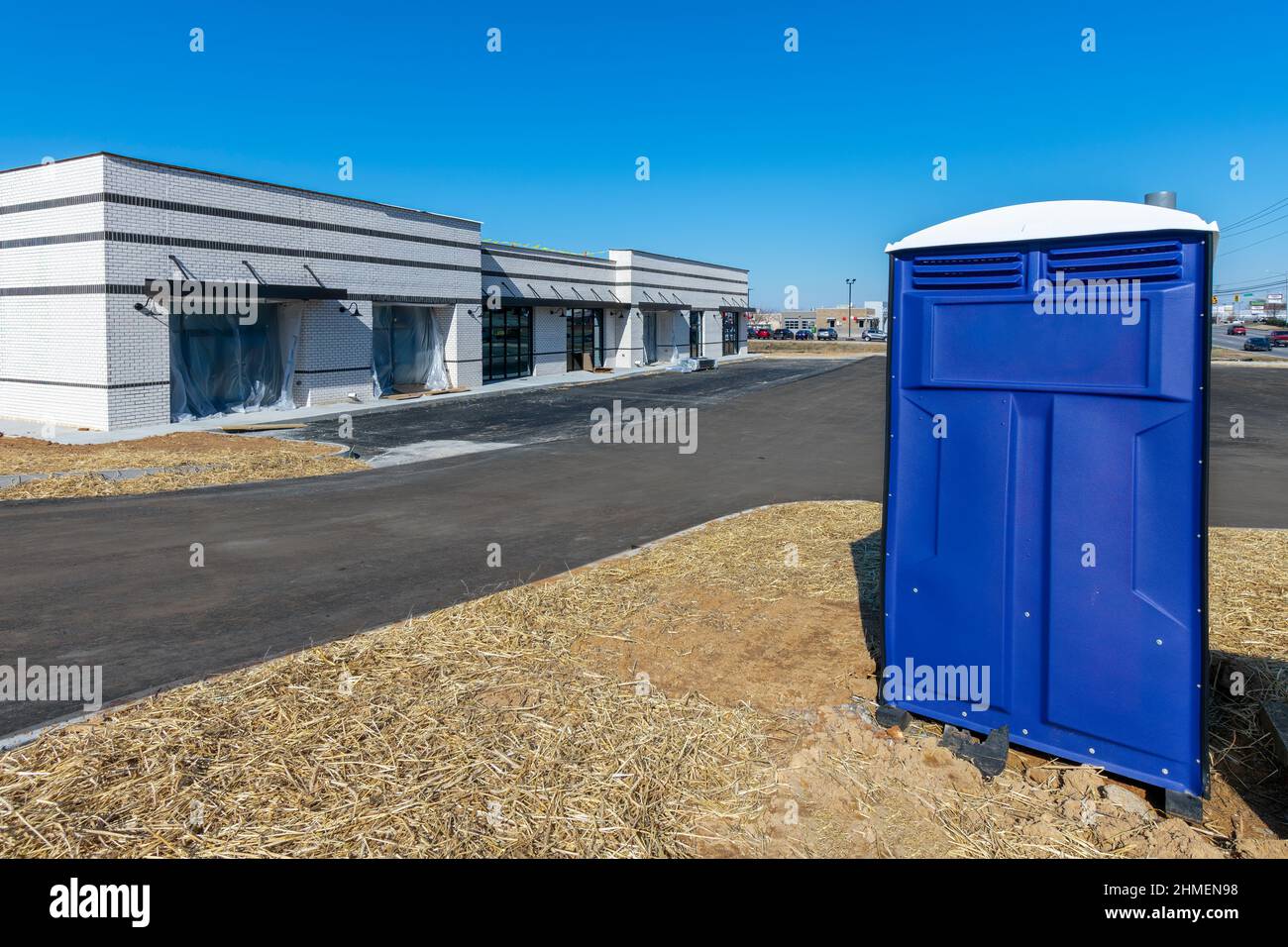 Scatto orizzontale di un gabinetto portatile sul bordo di un cantiere commerciale. Foto Stock