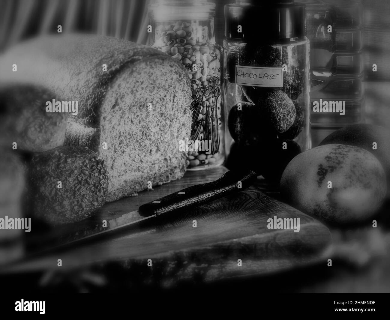 Moody cibo caldo ancora-vita di pane, cacao, mango, su tagliere rustico. Pane quotidiano Foto Stock