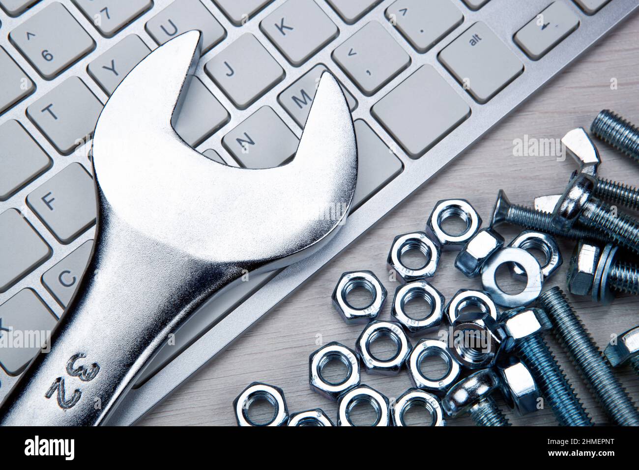 viti per il fissaggio di materiali e tastiera pc e una chiave closeup Foto Stock