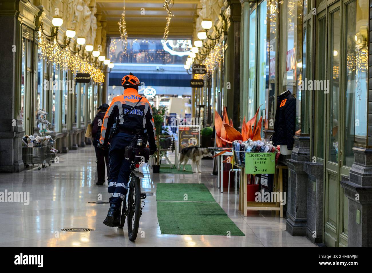 Vendita inverno a Bruxelles - poliziotto in pattuglia con una bicicletta Soldes d'hiver dans le centre de Bruxelles - Policier a velo en patrouille Foto Stock