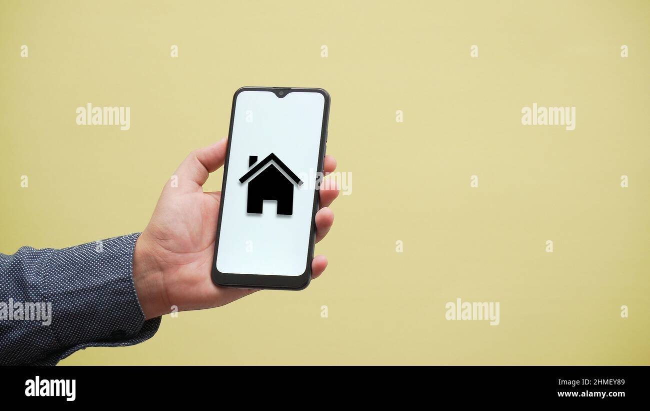 Persona che tiene un telefono con l'icona di ipoteca Foto Stock