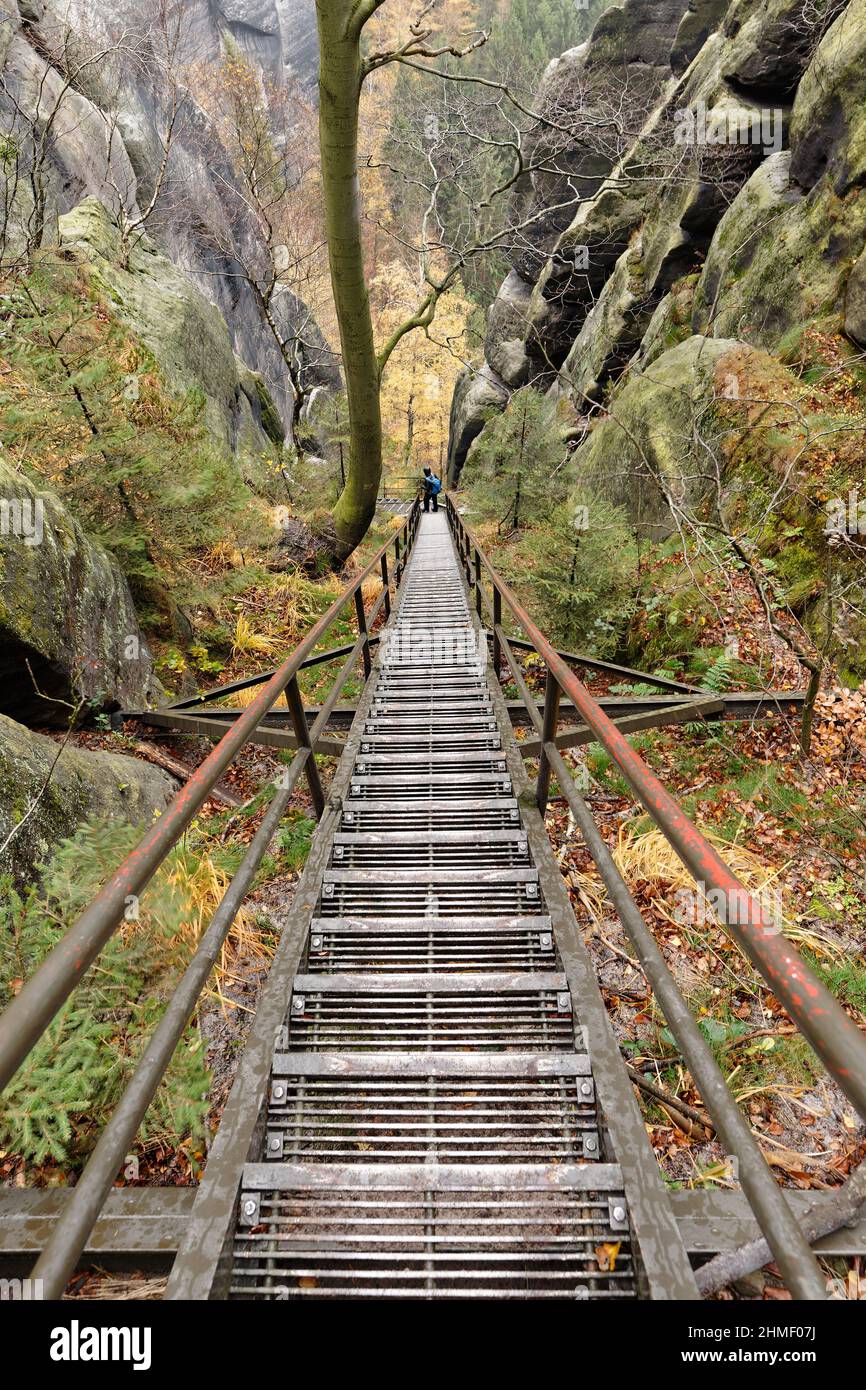 Montagne di arenaria dell'Elba, vista dall'alto sulle scale di metallo della "Scala Santa", la vista conduce a una persona, sentiero escursionistico, colori autunnali - Foto Stock
