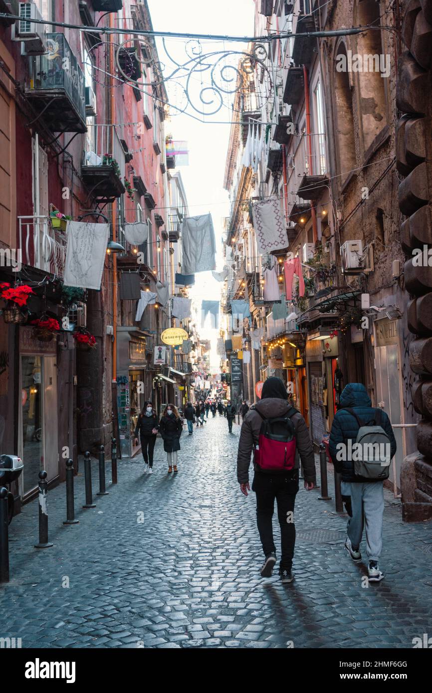 Napoli, Italia, 22 gennaio 2022: Strada stretta iconica nel centro di Napoli, la strada è piena di persone e di vita Foto Stock