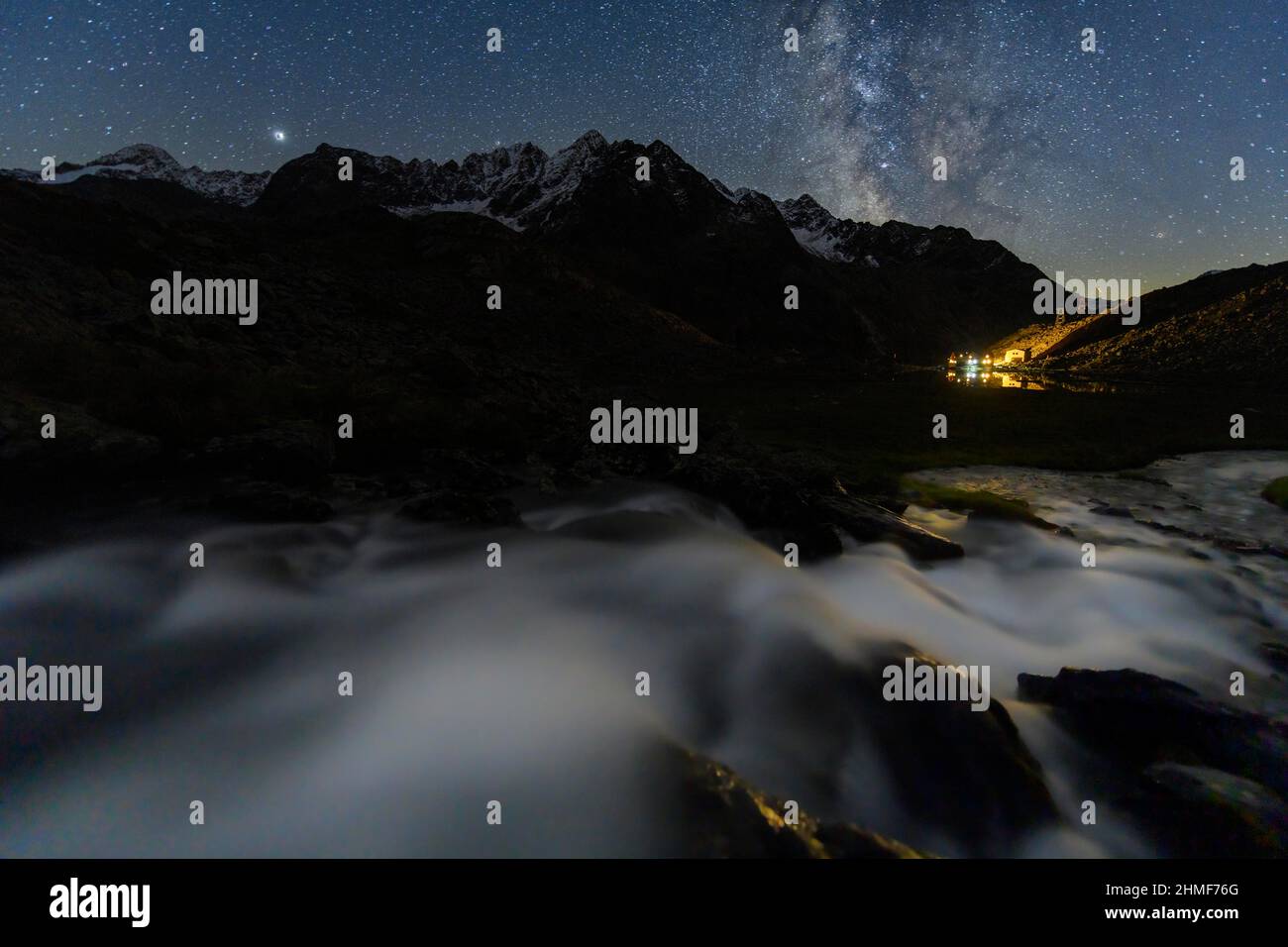 Torrente di montagna con capanna Winnebachsee e vette Winnebach con cielo stellato e Via Lattea, Sellrain, Innsbruck, Tirolo, Austria Foto Stock