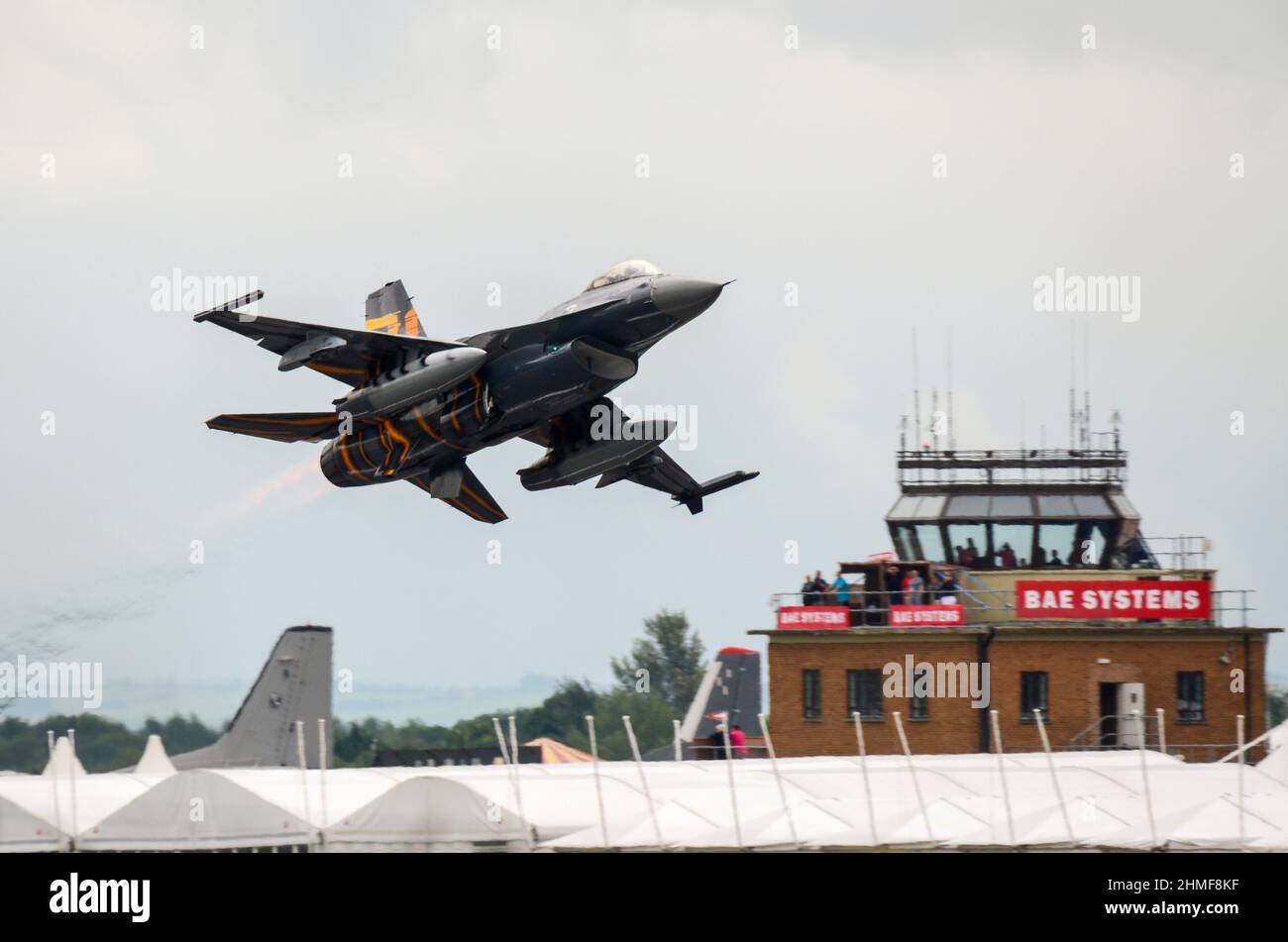 General Dynamics F-16 Fighting Falcon Jet decollo da RAF Fairford dopo il Royal International Air Tattoo Airshow, passando la torre di controllo bassa Foto Stock