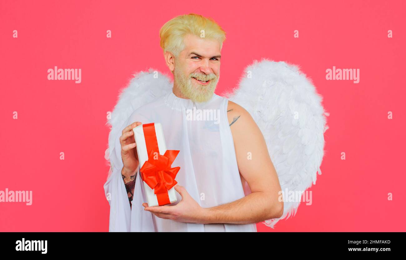 San Valentino Cupido con regalo. Angelo con presente. San Valentino. Uomo sorridente con ali bianche. Foto Stock