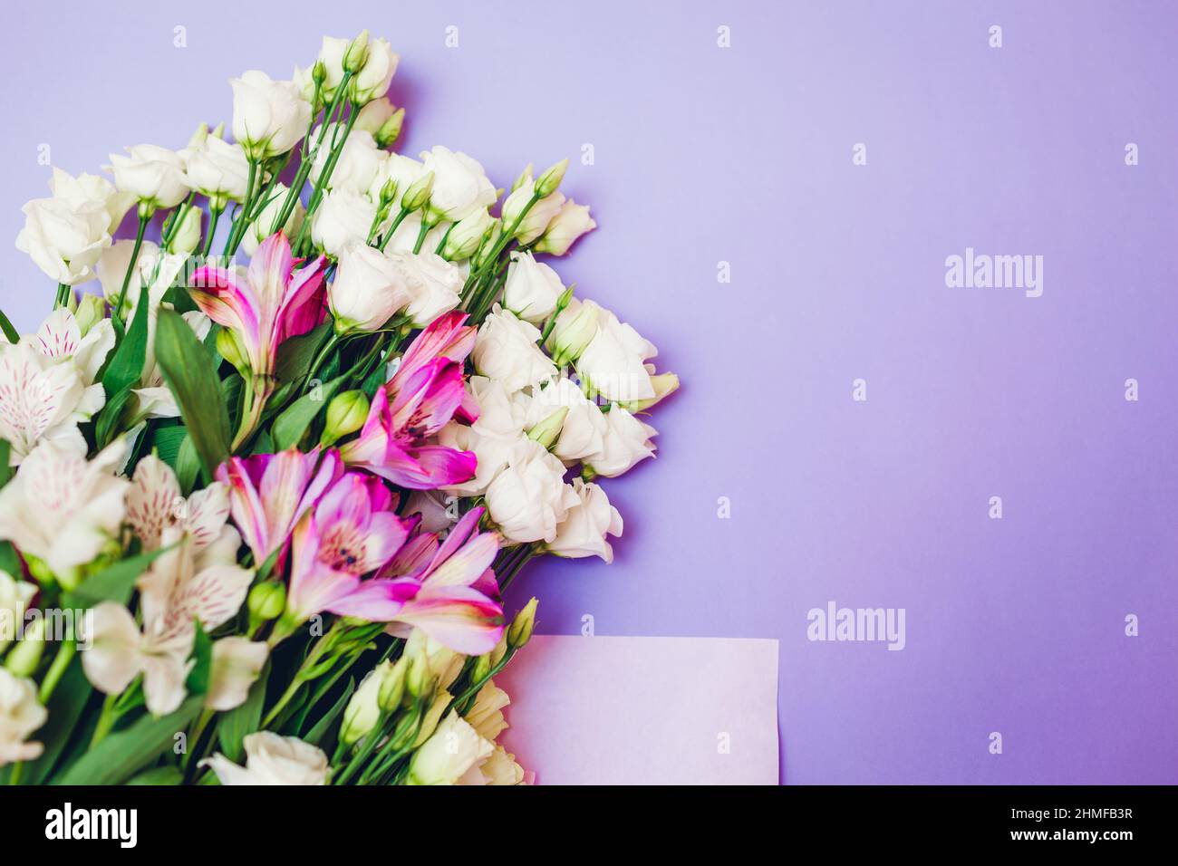 Fiori di primavera. Sfondo viola del giorno delle donne. Bouquet di eustoma bianco, rosa e alstroemeria. Regalo per la festa della mamma. Spazio Foto Stock