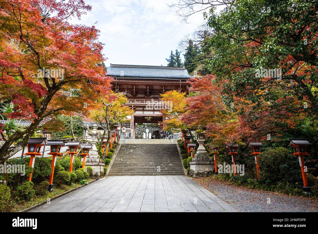 Un percorso fiancheggiato da lanterne con scale che conducono al Tempio Kurama-dere a nord di Kyoto, in Giappone, in una mattinata d'autunno. Foto Stock