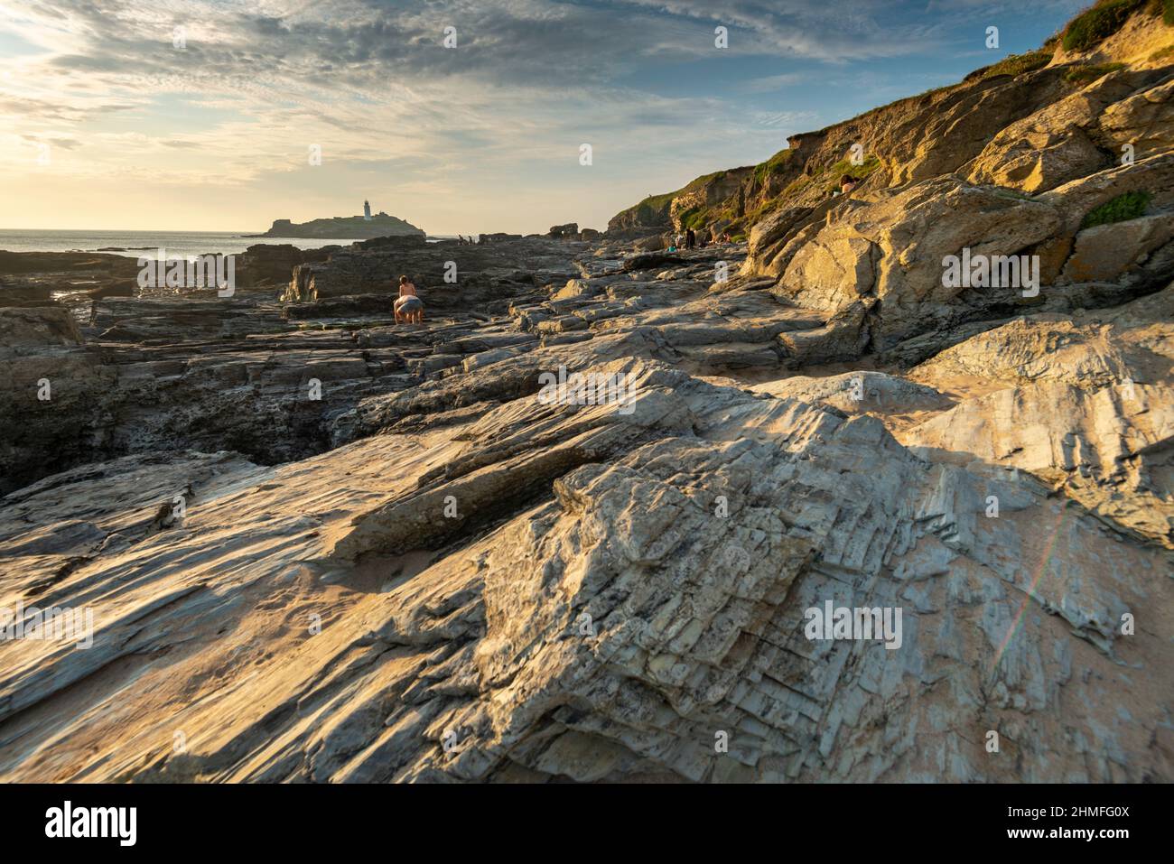 Godrevy,Cornovaglia,Inghilterra-Luglio 22nd 2021: Le famiglie godono il caldo sole estivo pomeridiano, mentre esplorano le insenature della spiaggia e le piscine di roccia, con Godrevy Foto Stock