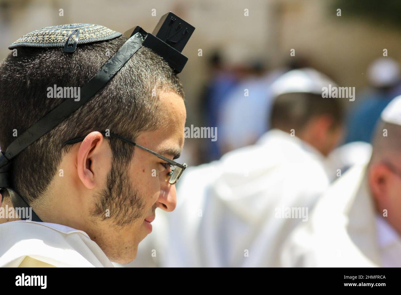 Un uomo ebreo osservante indossa un filterio, o tefillin, sulla sua testa. Foto Stock