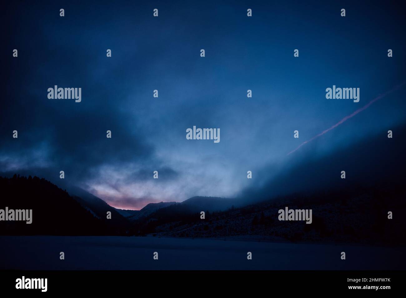 Spettacolare cielo serale durante l'ora blu con lievi sfumature rosa, sentiero di cime e montagne, crepuscolo. Foto Stock