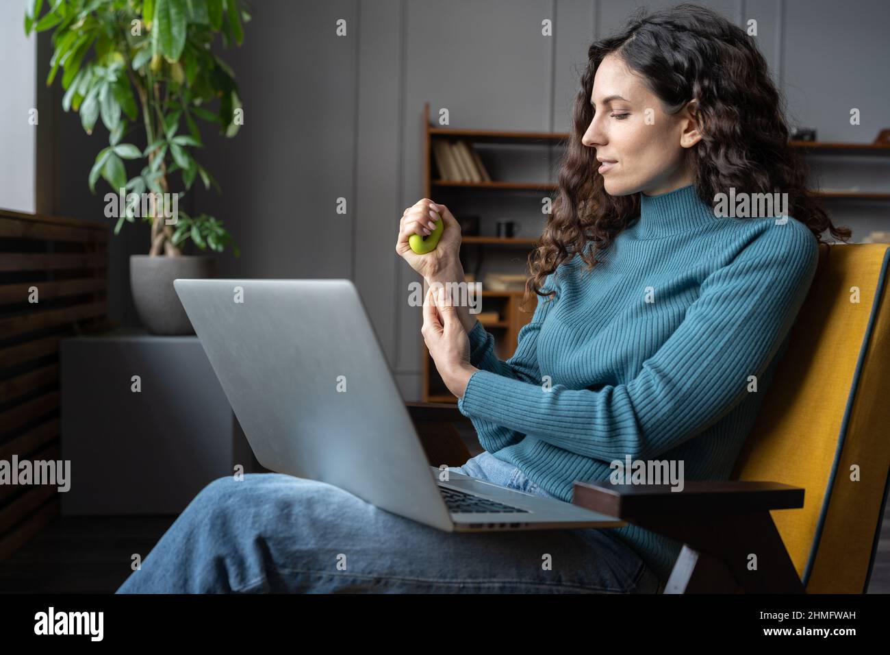 Dipendente femminile che si esercita con l'anello di presa in silicone che allevia lo stress, rilassante dal lavoro del computer Foto Stock