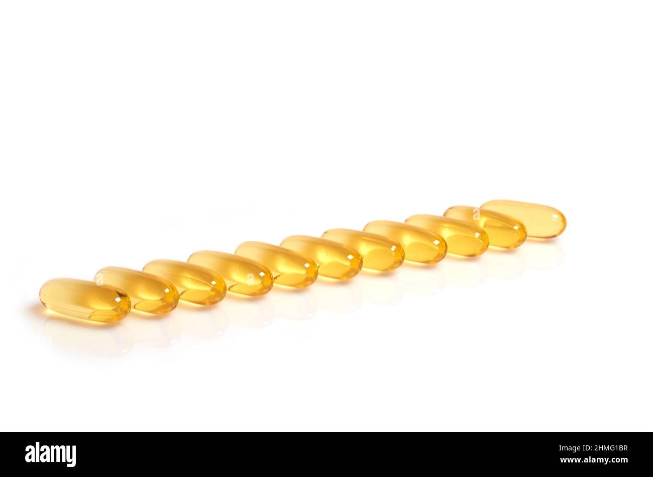 Molte capsule gialle di olio di pesce omega-3 gialle si trovano in fila Foto Stock