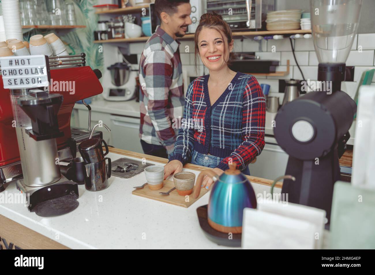 La giovane barista sorridente è al servizio della clientela Foto Stock