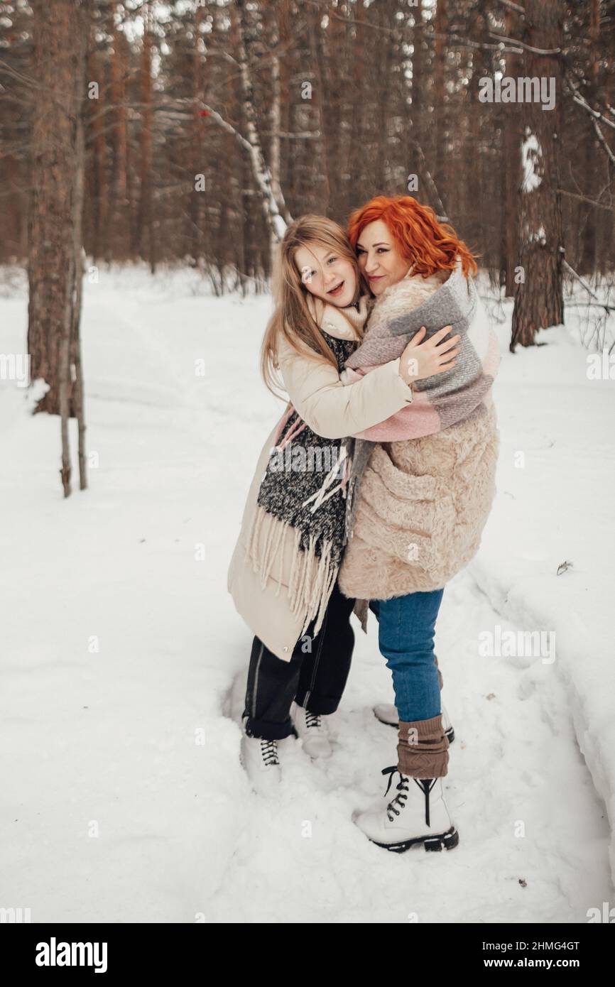 Una coppia innamorata, un uomo e una donna in una foresta invernale intorno a un fuoco bere caffè e dare marshmallows. Foto di alta qualità Foto Stock