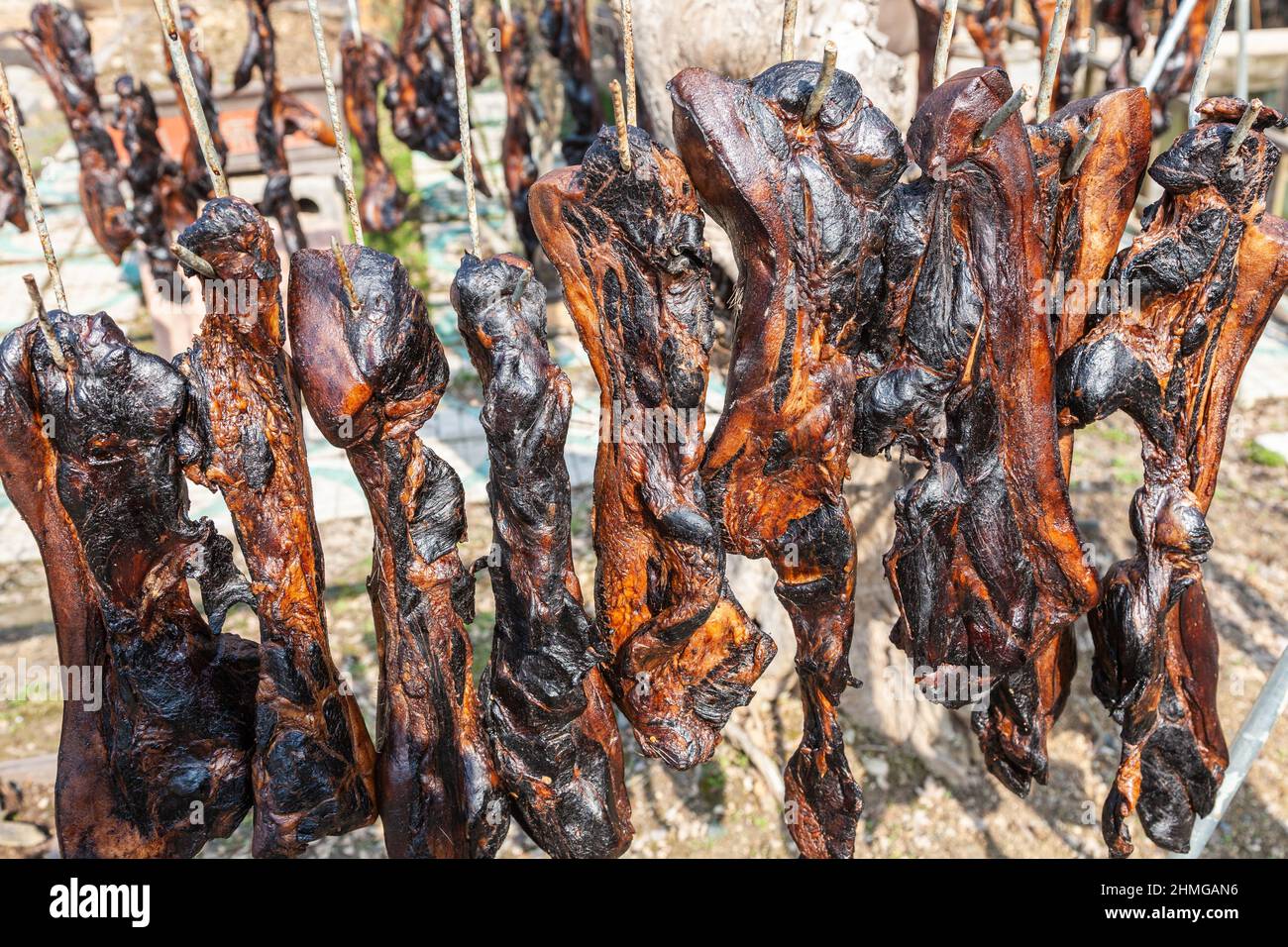 Quartieri di maiale disposti per asciugare al sole nel cortile di un ristorante a Hangzhou, Cina Foto Stock