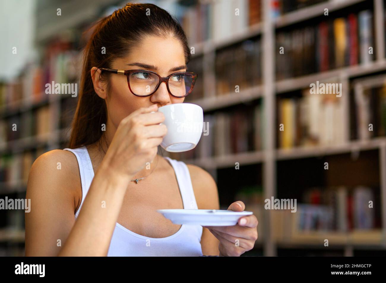 Ritratto di giovane donna felice godendo una tazza di caffè o tè os. Concetto di relax delle persone. Foto Stock