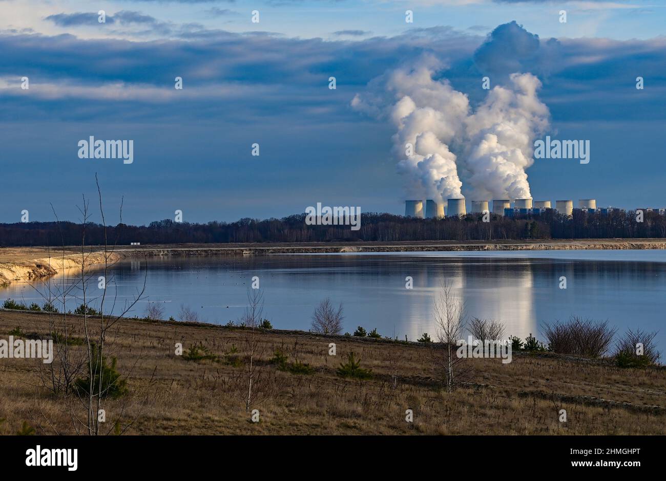 10 febbraio 2022, Brandeburgo, Cottbus: Vista sul bordo dell'ex miniera di lignite di Cottbus-Nord fino alla centrale elettrica alimentata a Jänschwalde lignite, dove il vapore sale dalle torri di raffreddamento. È qui che il futuro Cottbus East Lake sarà creato in pochi anni. L'alluvione è iniziata presso l'ex miniera a cielo aperto Cottbus-Nord a metà aprile 2019. La società di energia Lausitz Energie Bergbau AG (LEAG) consente all'acqua di fluire dallo Sprea attraverso il Hammergraben nella fossa aperta per l'allagamento, per un totale di circa 45 milioni di metri cubi all'anno. L'enorme lago artificiale è riferito di avere un Foto Stock