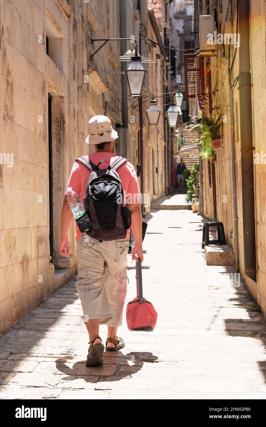 Passeggiate turistiche nel luogo storico alla luce del giorno. Parte storica della città. Tra pareti di case. Estate in Croazia, Dubrovnik. Foto Stock