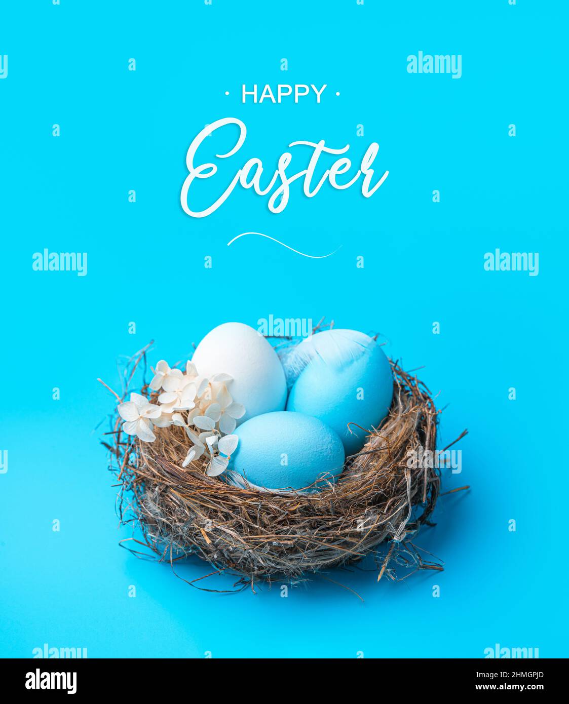 Un nido con uova di Pasqua colorate su sfondo blu. Il concetto di Buona Pasqua. Vista laterale. Foto Stock