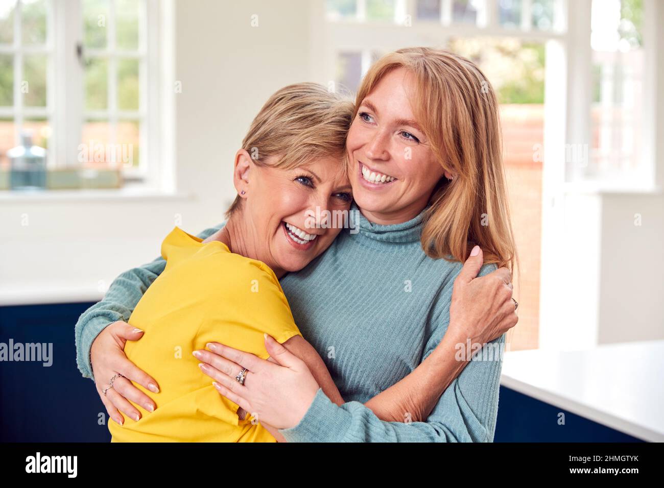Donna anziana saluto e abbracciando cresciuto figlia adulto a casa Foto Stock