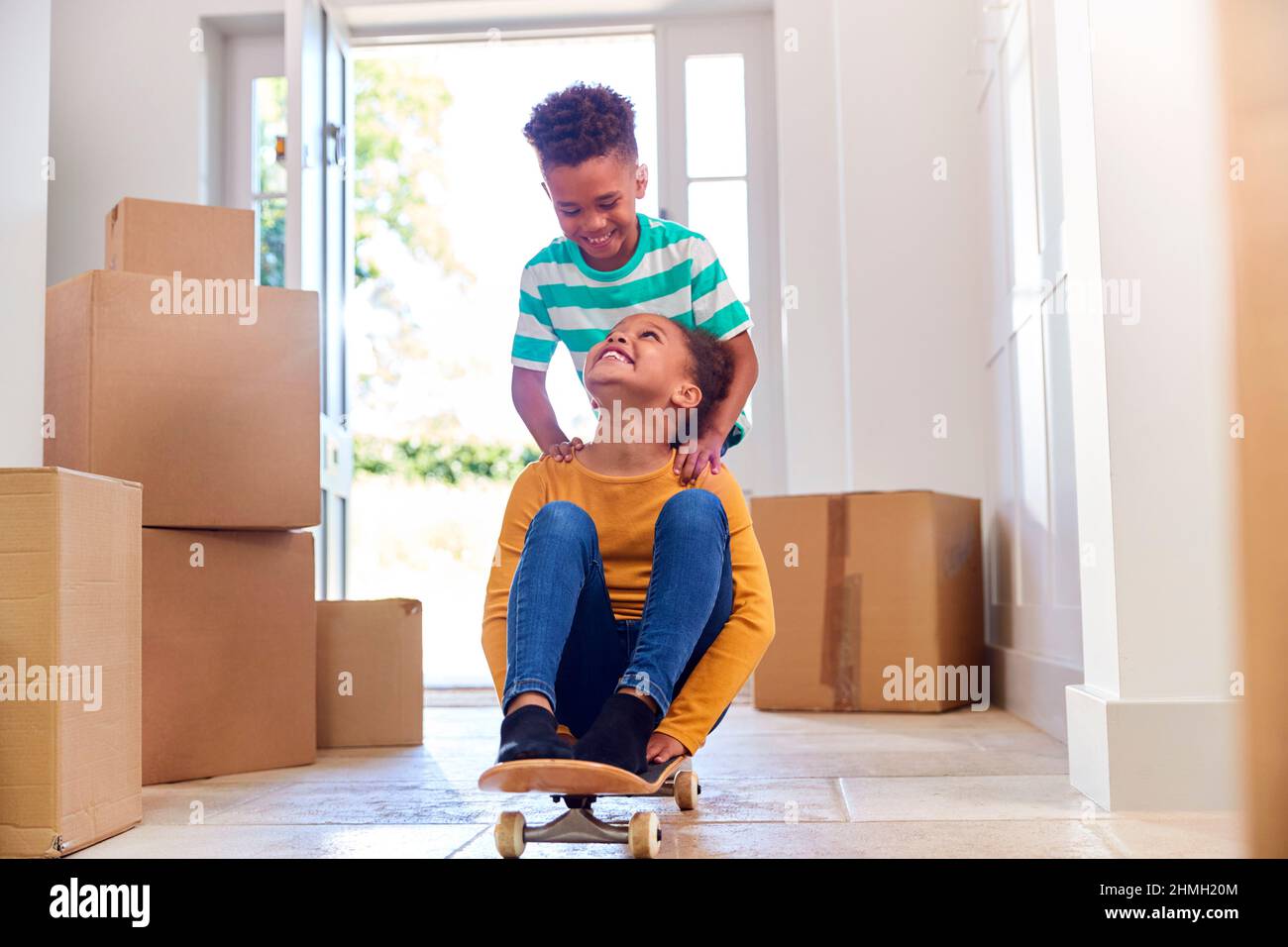 Due bambini con box in movimento in giorno giocando su skateboard Foto Stock