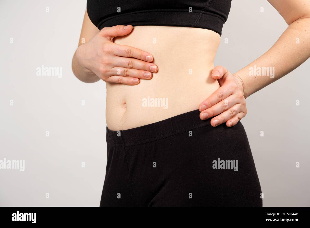 Una donna mostra la posizione del pancreas e della milza, l'intestino crasso. Un primo piano dell'addome. Foto Stock