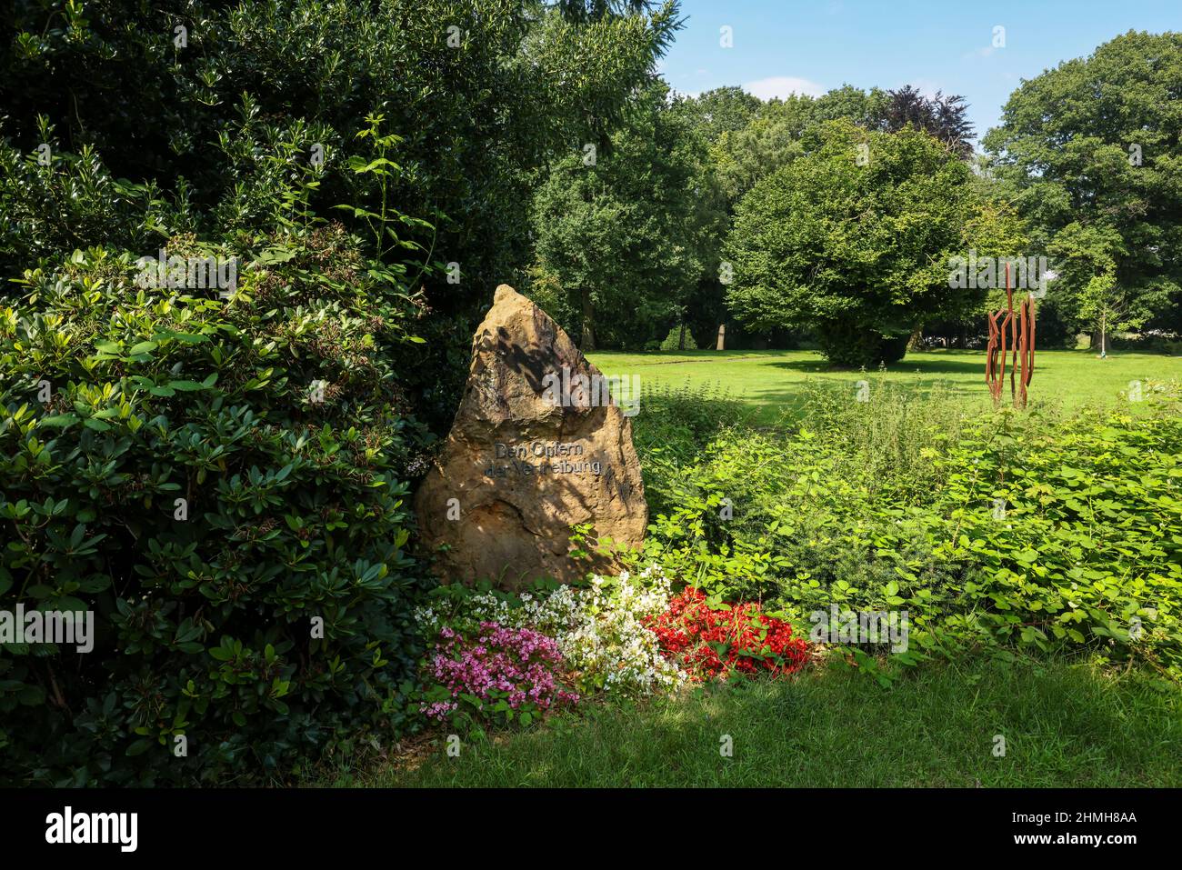 Marl, Renania settentrionale-Vestfalia, Germania - prima pietra commemorativa per le vittime dello sfollamento, nella parte posteriore dell'opera Merlak 2004 di Robert Schad, opera nel Parco della Pace, il vecchio cimitero di Brassert. Il vecchio cimitero, con il parco delle sculture e le sculture nello spazio pubblico, fa parte delle strutture all'aperto del museo delle sculture del Glaskasten. Foto Stock