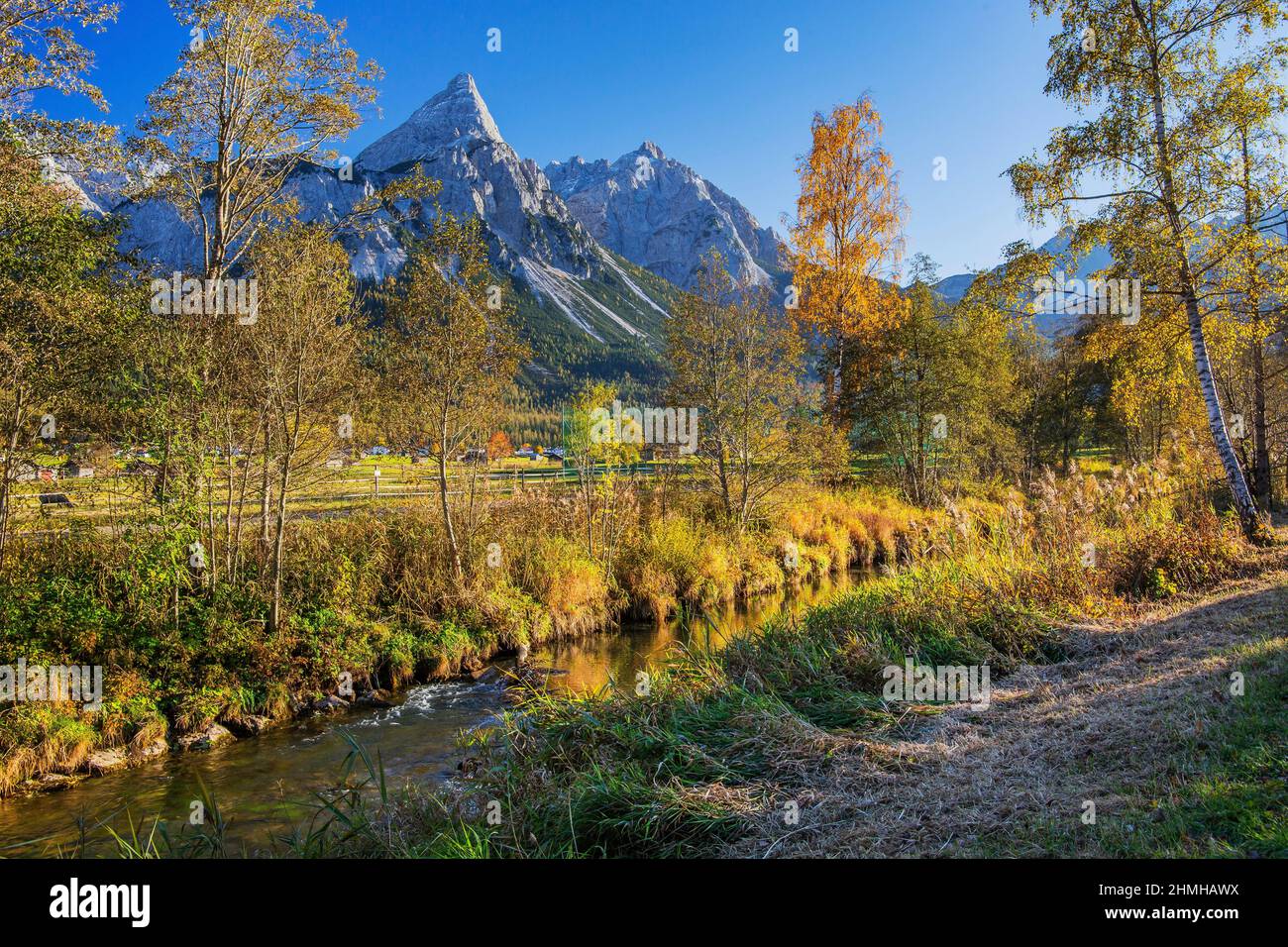 Paesaggio autunnale con un ruscello nel Lermooser Moos contro il Sonnenspitze 2417m nella catena Mieminger, Ehrwald, Loisachtal, Tirolo, Austria Foto Stock