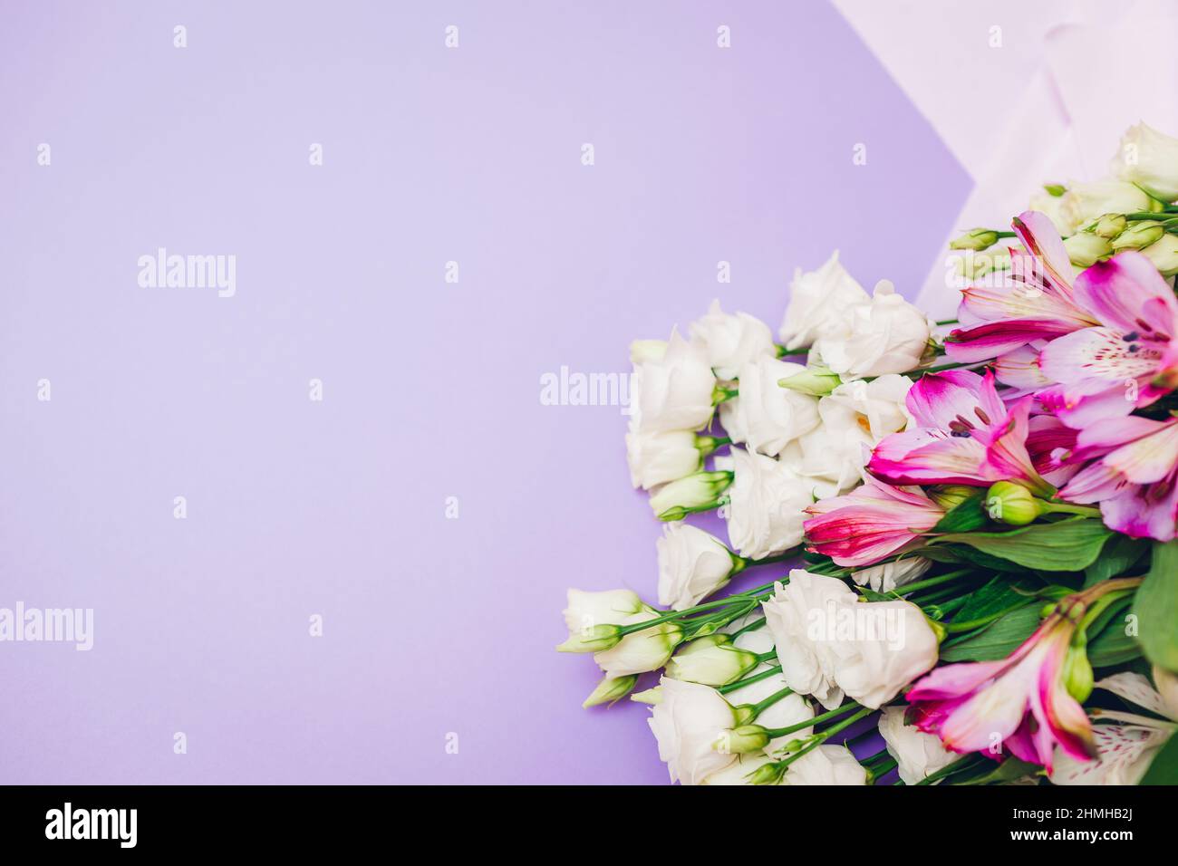 Fiori di primavera. Giornata internazionale delle donne sfondo viola. Bouquet di eustoma bianco, rosa e alstroemeria. Regalo per la festa della mamma. Spazio Foto Stock