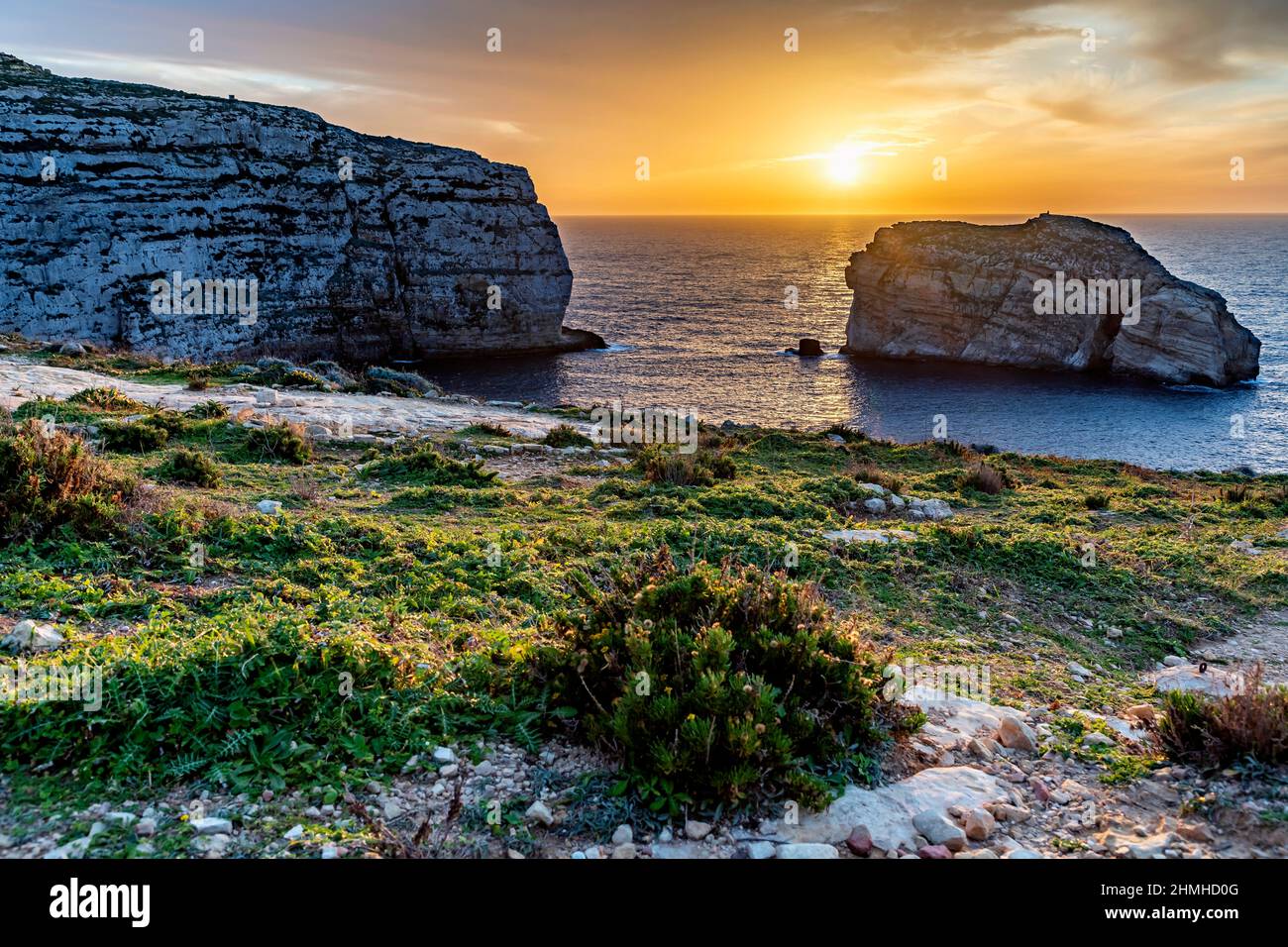 Il sole tramonta in colori gloriosi sulla Baia di Dwejra a Gozo Foto Stock