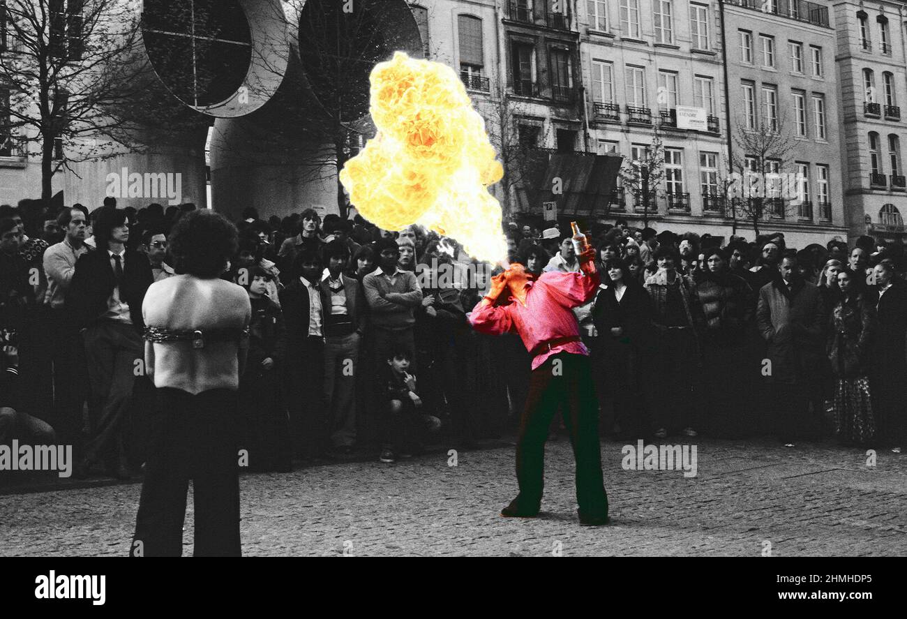 L'immagine archivistica di Un lanciafiamme intrattiene la folla fuori dal Centro Pompidou di Parigi, mentre un artista di fuga attende il suo turno. Scatto di archivio Foto Stock