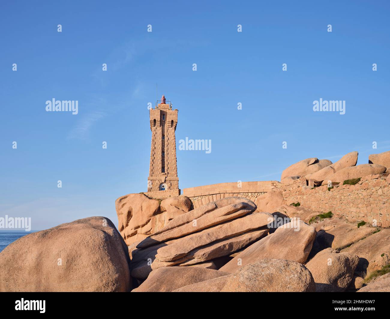 Phare de Ploumanac'h nel sole del pomeriggio sulla Côte de Granit Rose nel dipartimento della Côtes d'Armor della Bretagna. Il faro è stato costruito dal granito rosa della costa rocciosa e si fonde armoniosamente con i dintorni Foto Stock