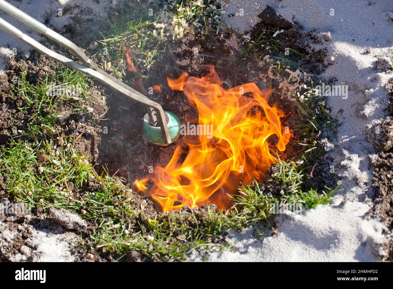 Raku fuoco, un oggetto è estratto dal buco fuoco con le pinze Foto Stock