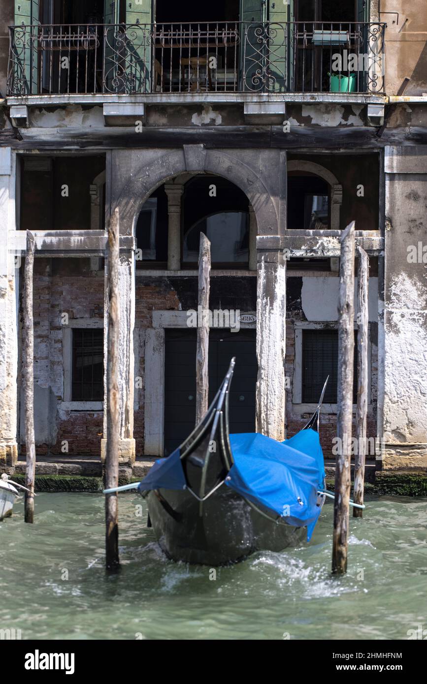 Singola gondola alle onde di fronte ad un vecchio edificio sul Canal Grande di Venezia Foto Stock