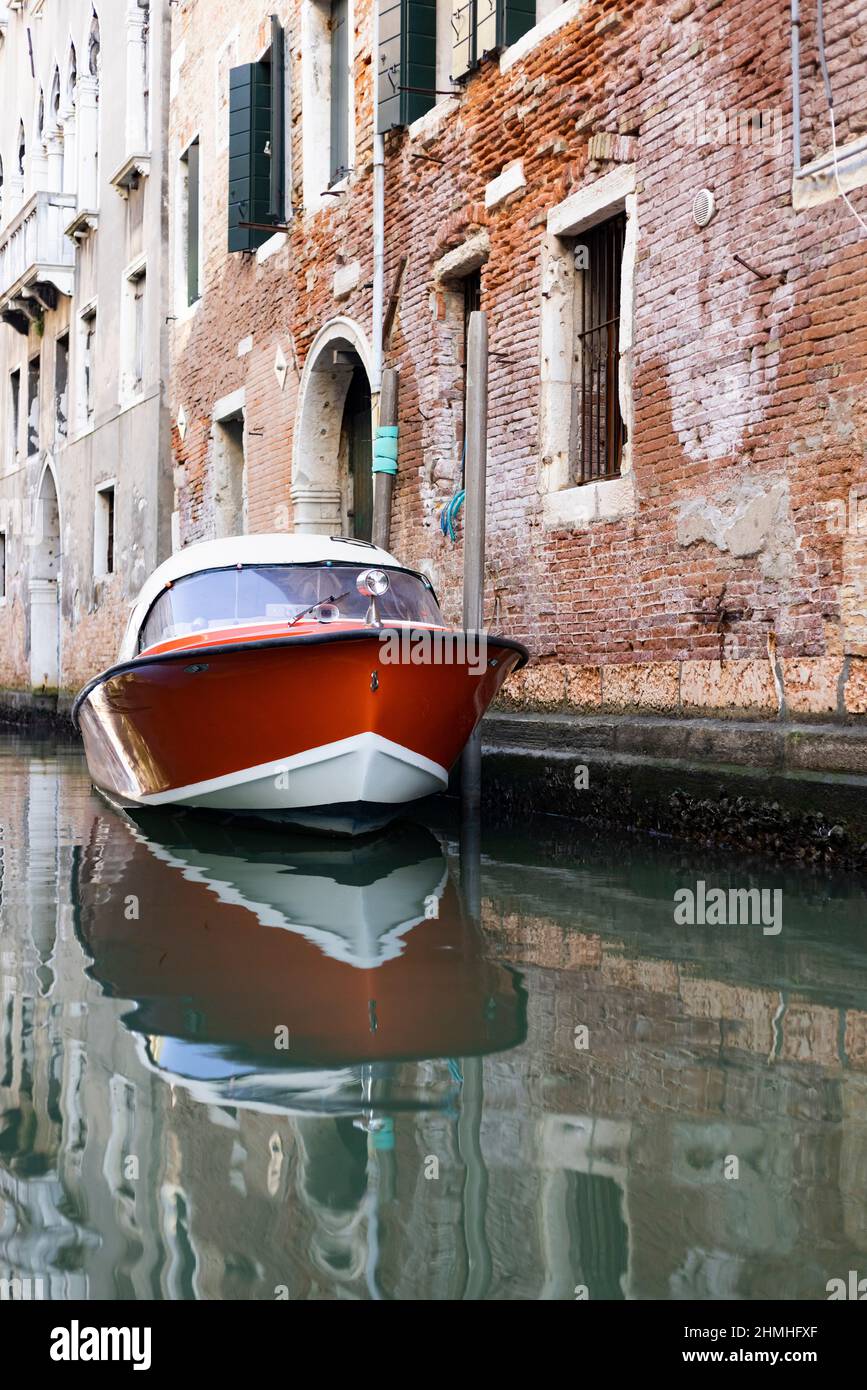 Moderno motoscafo di fronte ad un edificio che necessita di ristrutturazione a Venezia Foto Stock