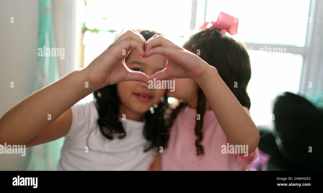 I bambini che fanno il simbolo del cuore con le mani insieme primo piano Foto Stock