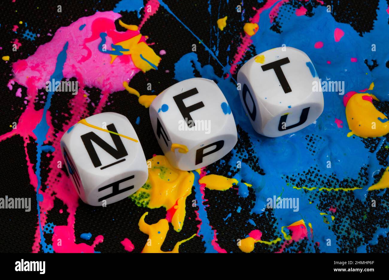 NFT in lettere dice con spruzzi di vernice in più colori Foto Stock