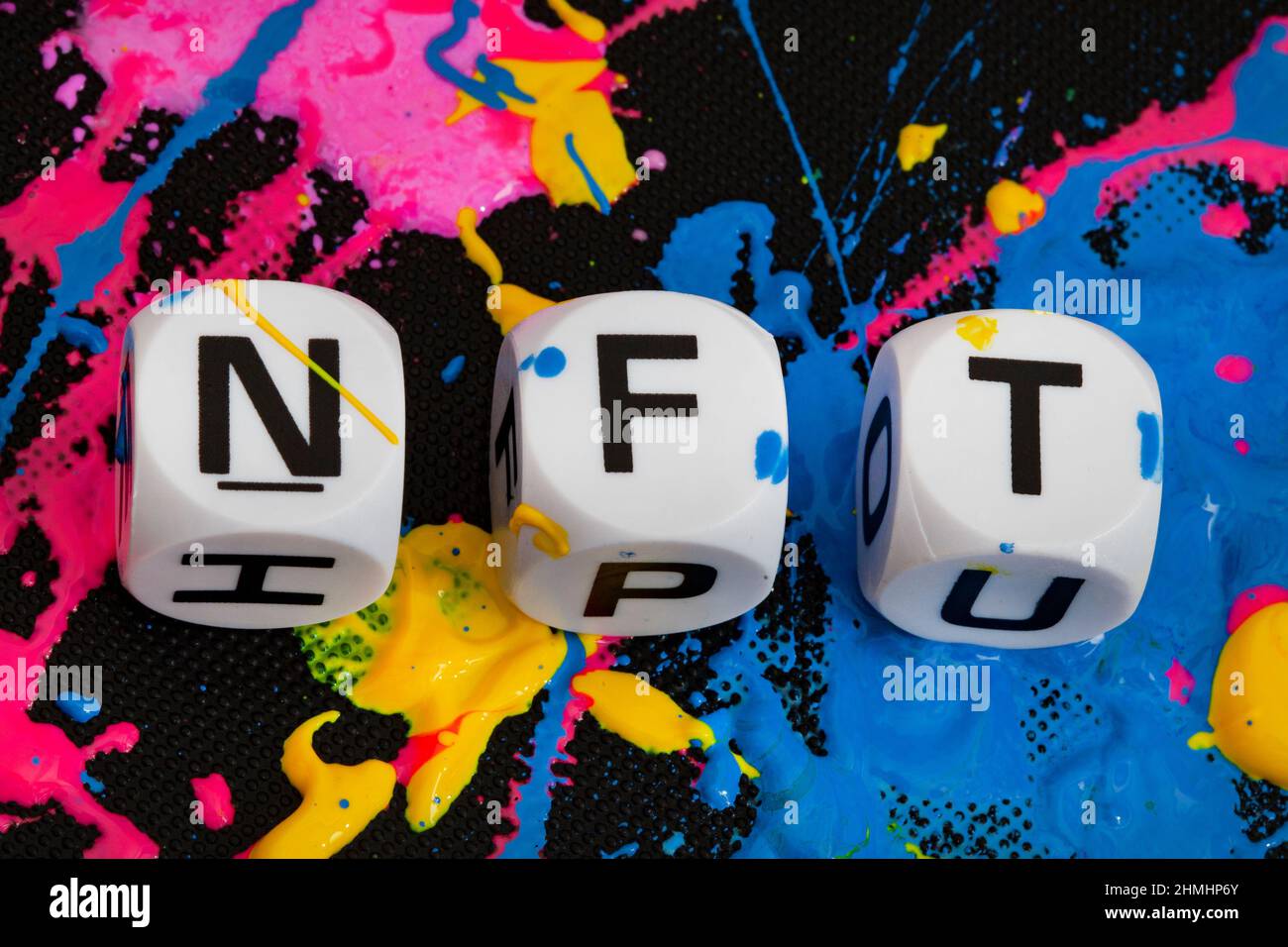 NFT in lettere dice con spruzzi di vernice in più colori Foto Stock