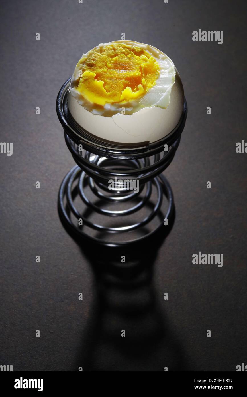 Uovo bollito morbido nel bicchiere. Tuorlo d'uovo runny e succoso. Guscio dell'uovo incrinato Foto Stock