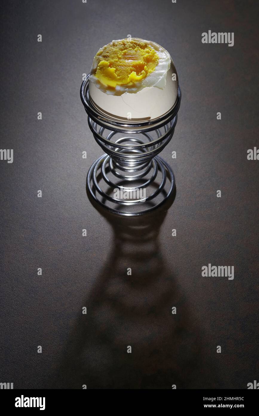 Uovo bollito morbido nel bicchiere. Tuorlo d'uovo runny e succoso. Guscio dell'uovo incrinato Foto Stock