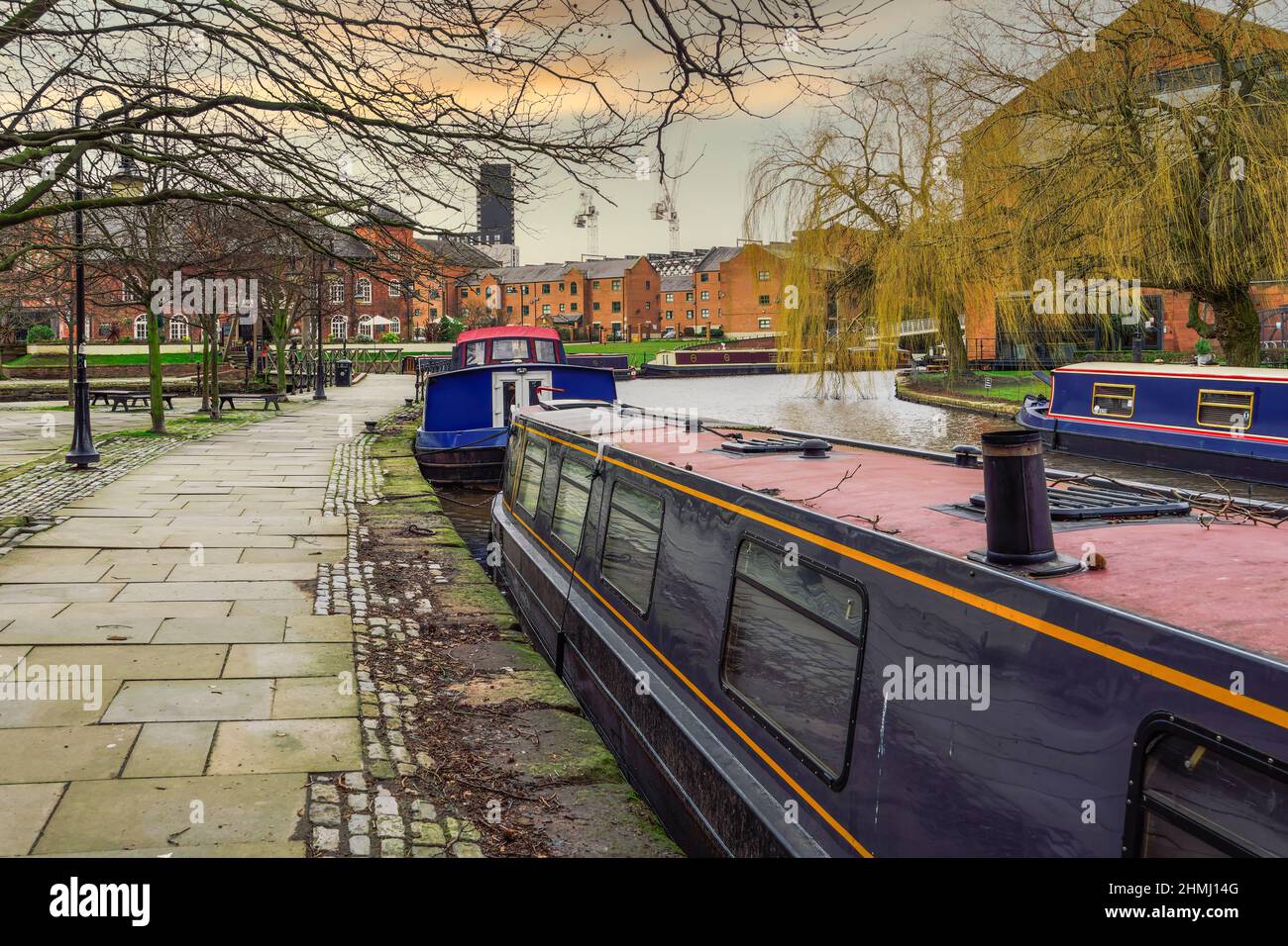 Manchester, Regno Unito ormeggiate barche strette nella zona di Castlefield Basin. Case galleggianti sul canale Bridgewater, prima dei tradizionali edifici bassi. Foto Stock