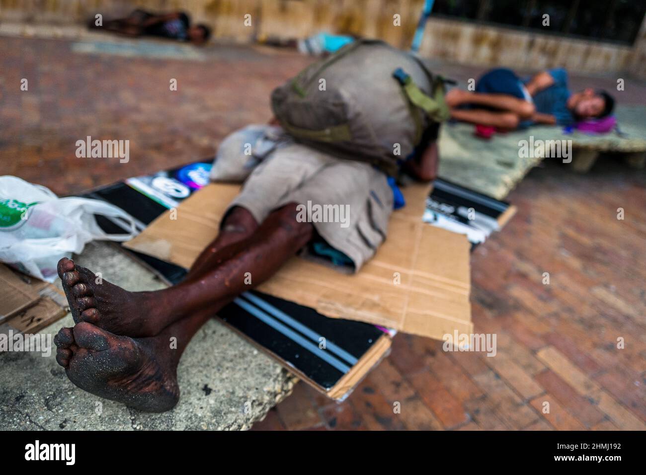 I senzatetto afro-colombiani dormono sul cartone nel centro storico di Cartagena, Colombia. Foto Stock