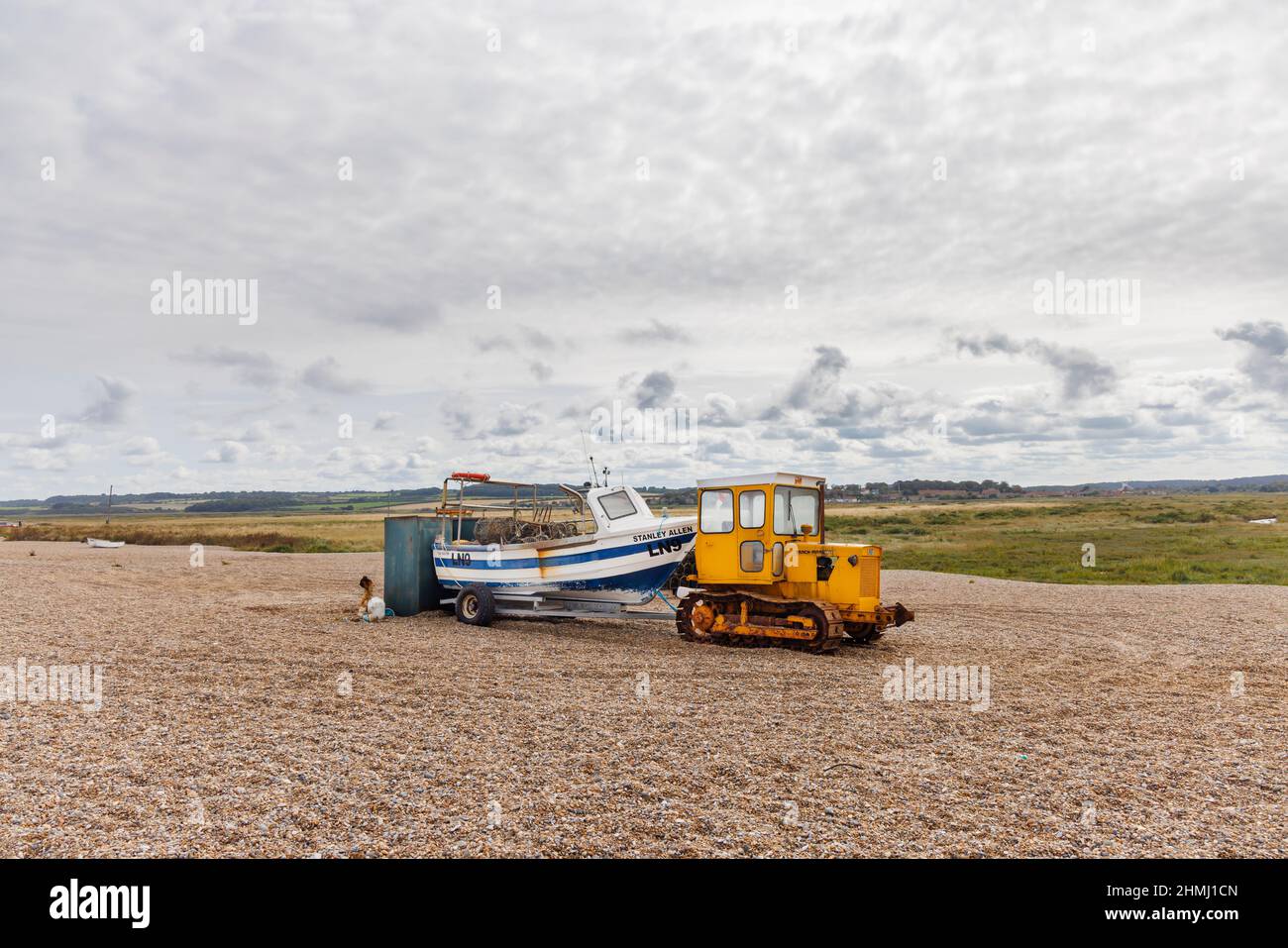 Barca da pesca su un rimorchio trainato da un apripista cingolato cingolato su una spiaggia di ghiaia, Cley-Next-the-Sea, un villaggio costiero a Norfolk, East Anglia, Inghilterra Foto Stock