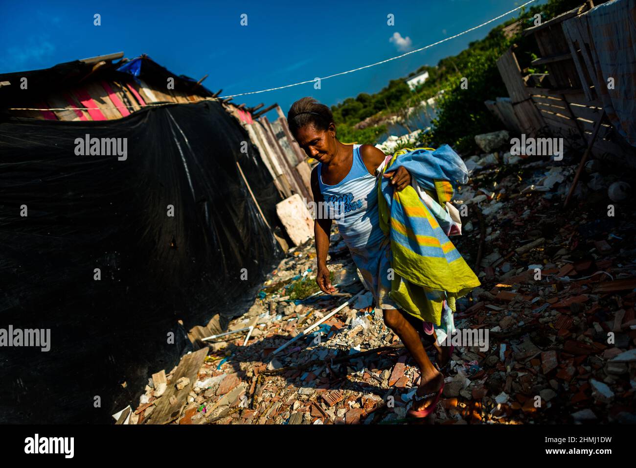 Una donna afro-colombiana porta la lavanderia ad asciugare fuori dalla sua casa a Olaya Herrera, un quartiere di classe sociale bassa a Cartagena, Colombia. Foto Stock