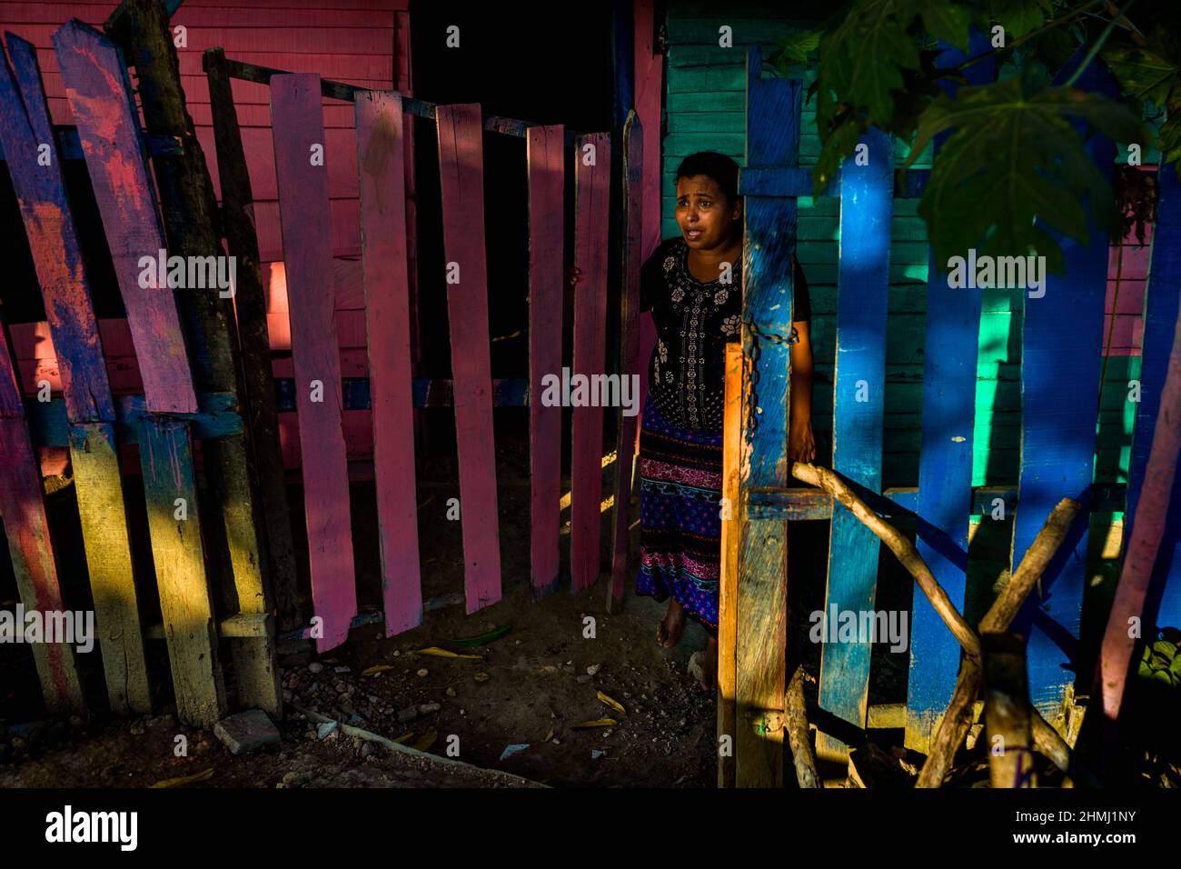 Una donna afro-colombiana chiama in silenzio i suoi figli a Olaya Herrera, un quartiere di classe sociale bassa a Cartagena, Colombia. Foto Stock