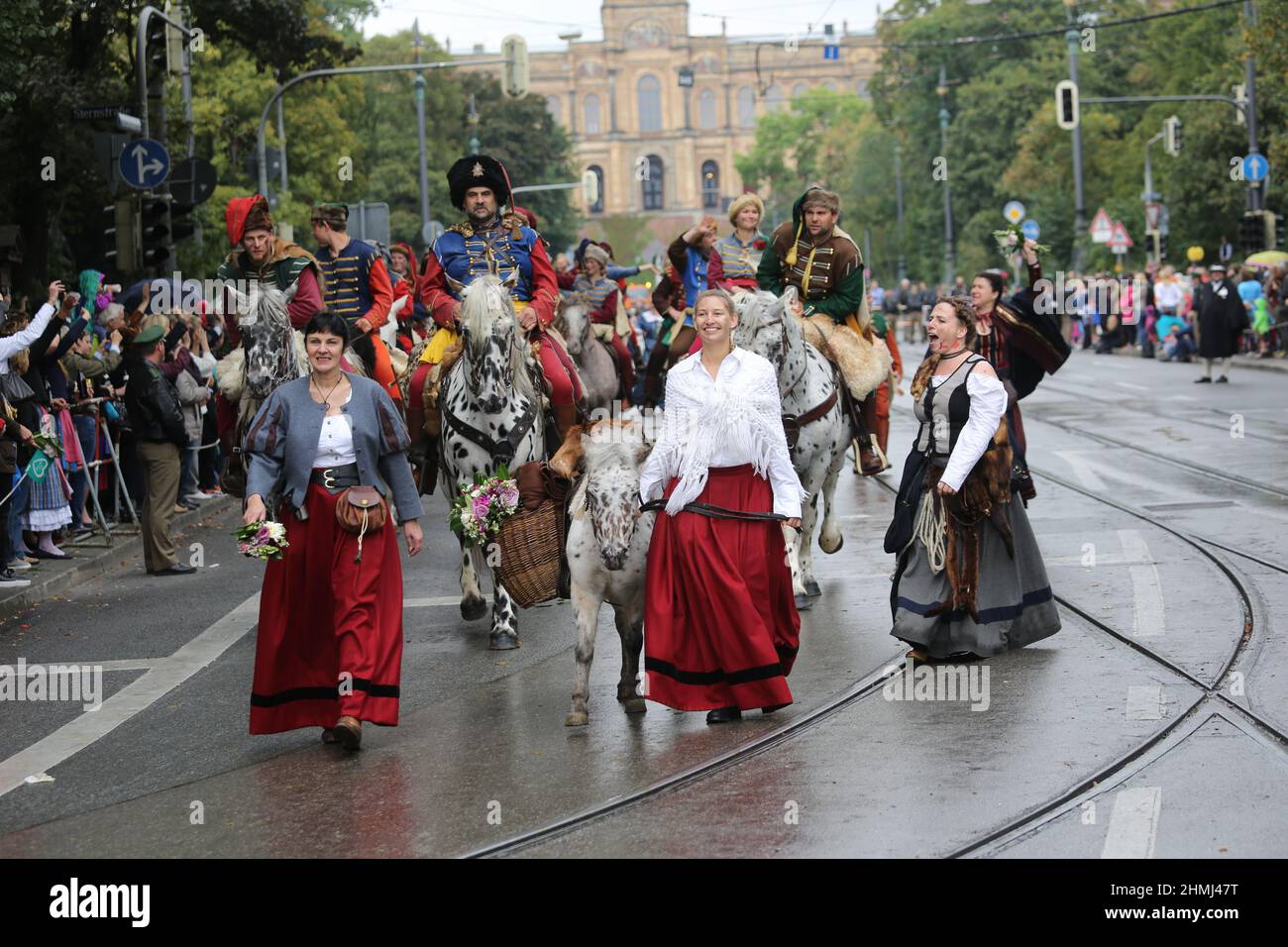 I partecipanti alla sfilata dell'Oktoberfest camminano per le strade di Monaco in abbigliamento tradizionale tracht. Foto Stock